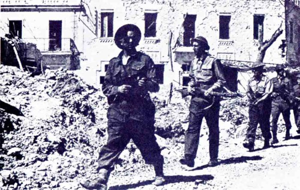 7 maggio 1943. Tra le macerie di una strada di Biserta, una pattuglia di soldati inglesi è impegnata in un'azione di rastrellamento.